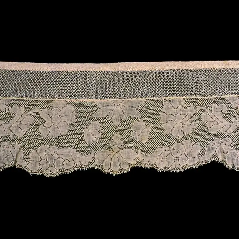 Blush-toned floral lace edging on a dark background